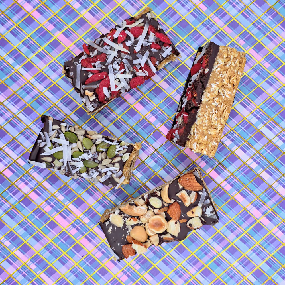 Portioned pieces of the chocolate chickpea slice. Toppings included. Mixed seeds and coconut, goji berries and coconut and mixed nuts.