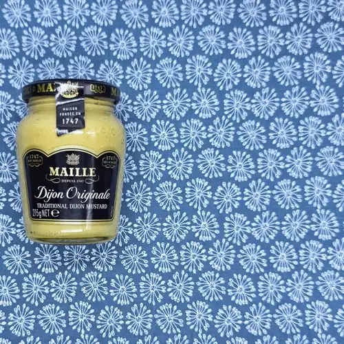 Maille Dijon Originale. Traditional Dijon mustard. Founded 1747. Made in France. Available from Woolworths, Coles, Farmer Jack's and IGA. 26% mustard seeds. Sugars 2.0g per 100g. Sodium 1930mg per 100g.