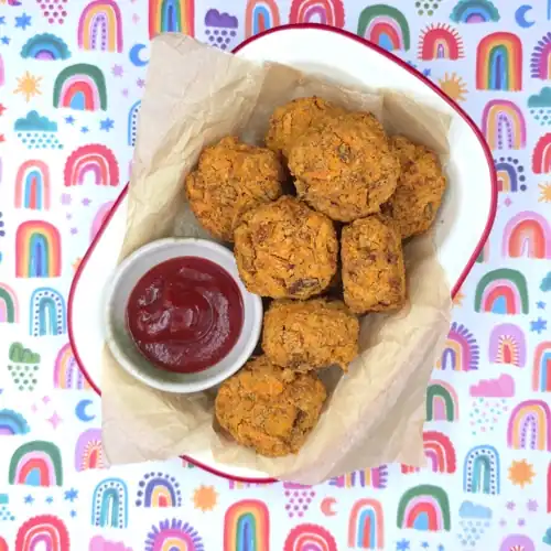 Crispy baked Veggie Nuggets served on a plate with a dipping bowl of tomato sauce.